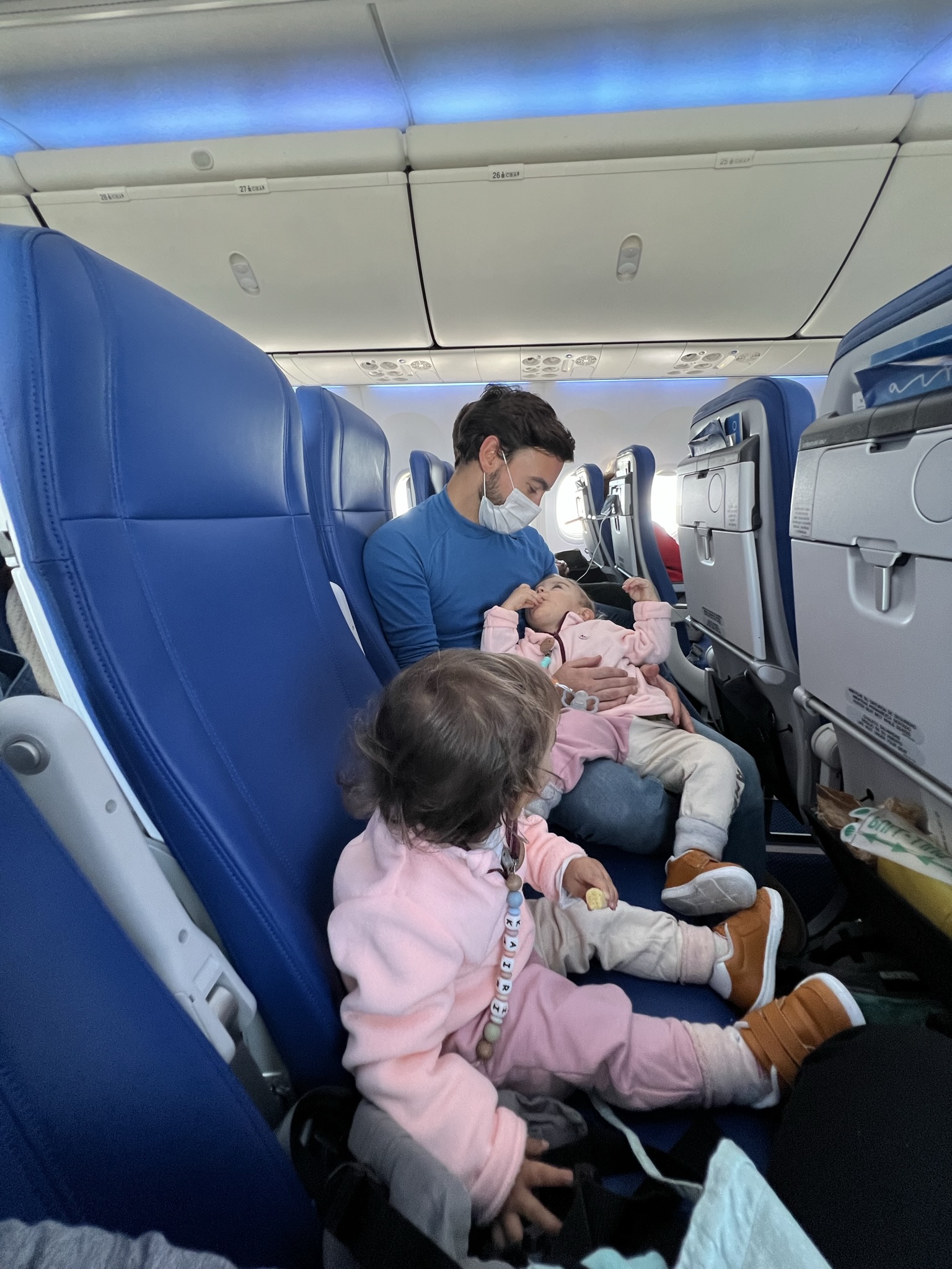 volar con bebés, padre jugando con hijos en avión